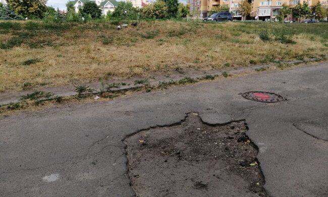 Жителі столичної Оболоні скаржаться на величезні дірки в асфальті, які нагадують кратери (фото)