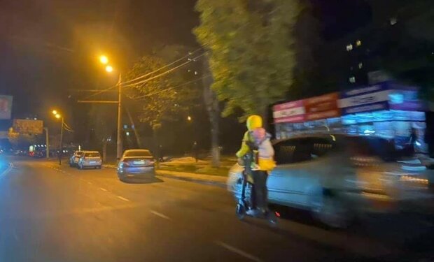 Жінка на електросамокаті з двома дітьми ганяла між автівками (фото)