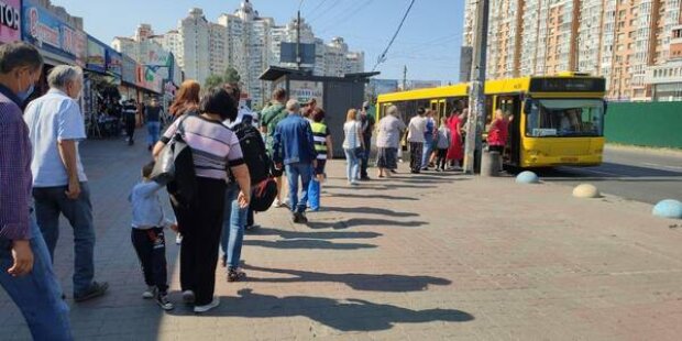 кияни чекають автобуси, стоячи у довжелезних чергах