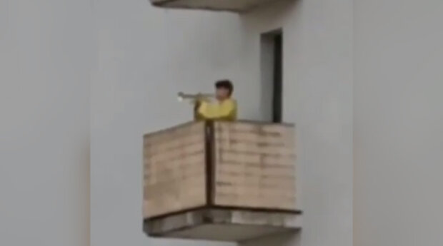 “Під звуки вибухів”: у Києві трубач вийшов на балкон та почав грати Гімн України (відео)