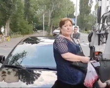 У Києві жінка сіла на капот автомобіля, щоб її не забрав евакуатор (відео)