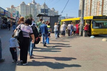 кияни чекають автобуси, стоячи у довжелезних чергах