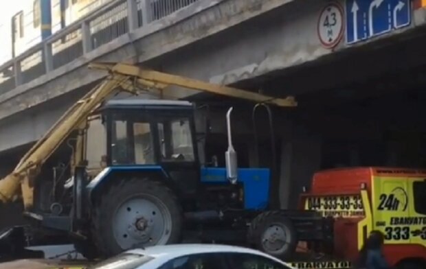 У Києві під мостом застряг евакуатор із трактором (відео)
