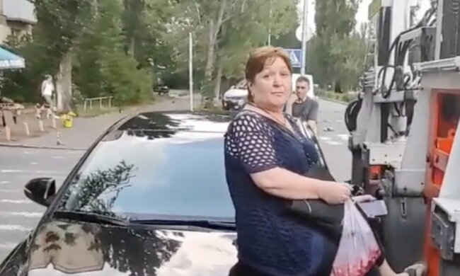 У Києві жінка сіла на капот автомобіля, щоб її не забрав евакуатор (відео)
